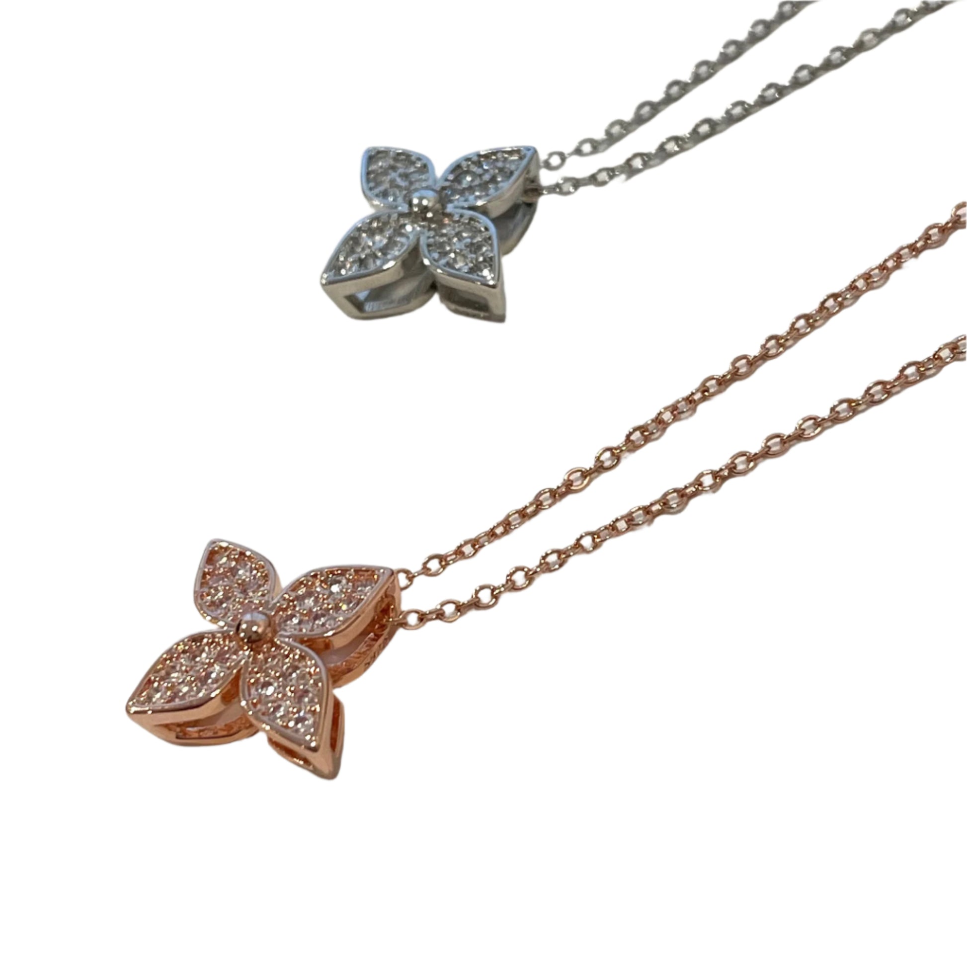 flower-shaped pendants on rose gold and silver chains against a light background